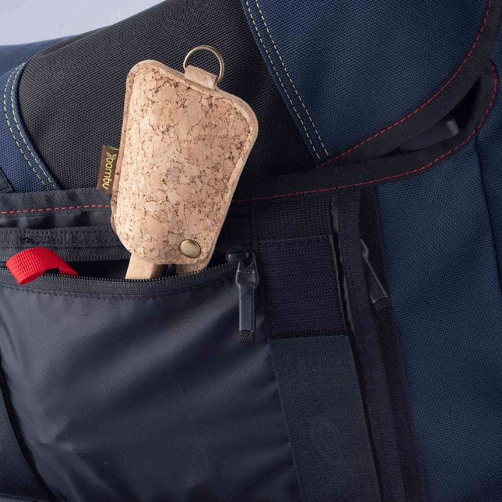 Bamboo utensil set, shown in cork sleeve tucked in zippered pocket of blue and black bag.