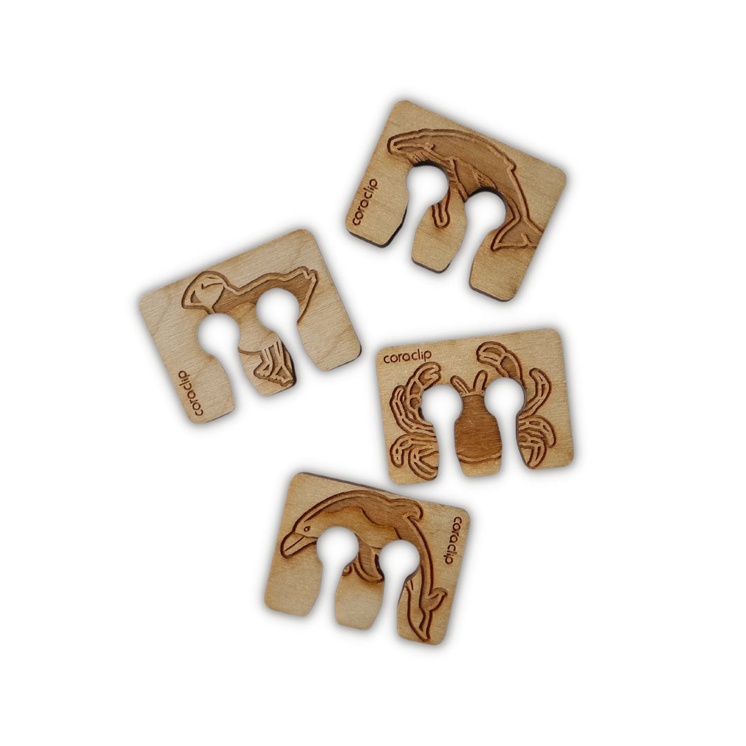 Wooden bag clip Collection B, clockwise from top: Whale, Crab, Dolphin, and Puffin designs.