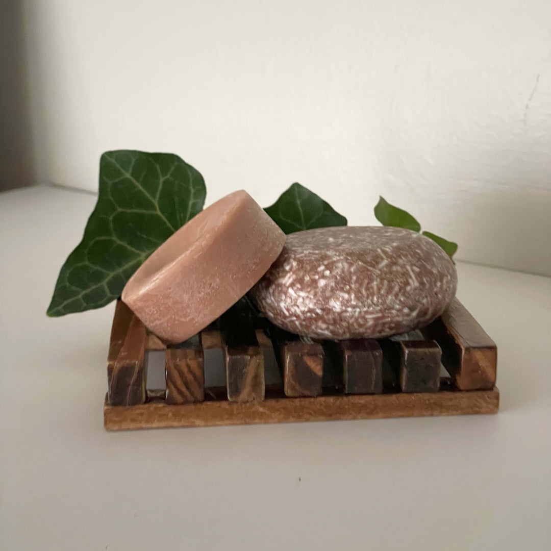 Humby Shampoo Bar and Humby Conditioner Bar in Sandalwood Serenity scent with greenery in background.