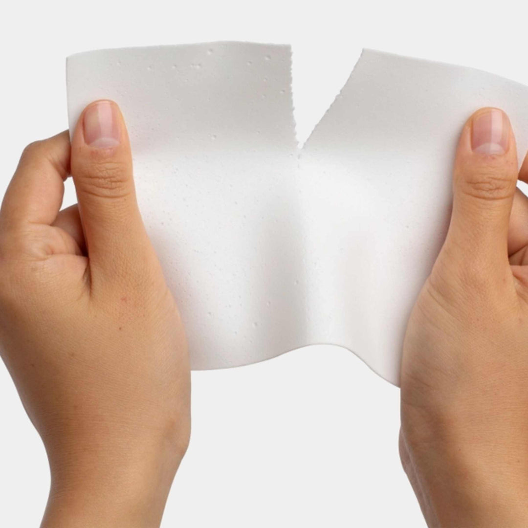 Eco friendly laundry detergent sheets being separated with hands.