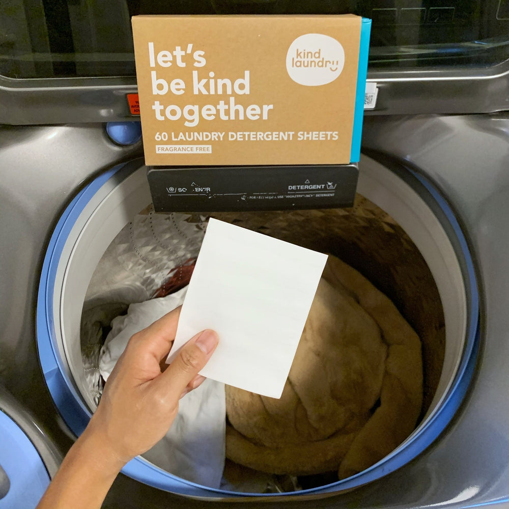 Kind Laundry Eco Friendly Detergent Sheet Being Placed In Washing Machine.