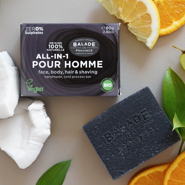 All In One Bar for face, body, hair, and shaving, shown with plastic-free cardboard packaging and surrounded by fruit and greenery.
