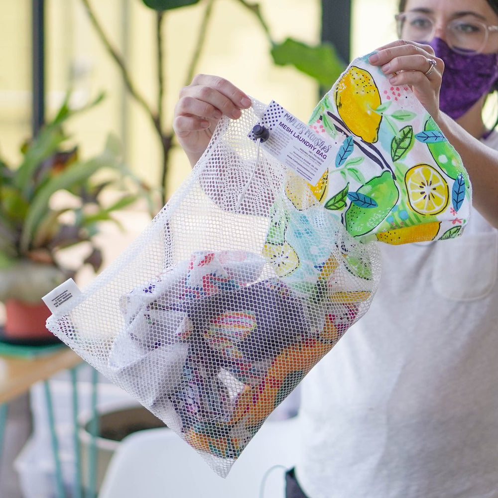 Woman Filling Marleys Monsters Large Mesh Laundry Bag.